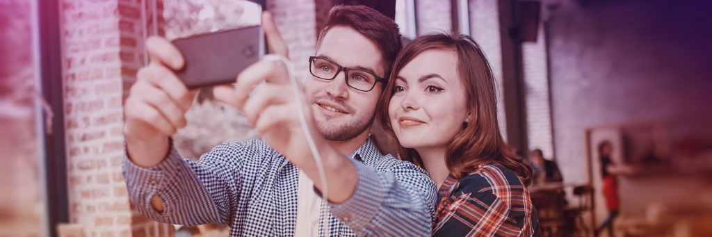 Image of millennial couple posing for selfie
