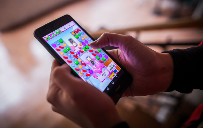 Smartphone user playing Candy Crush Game App