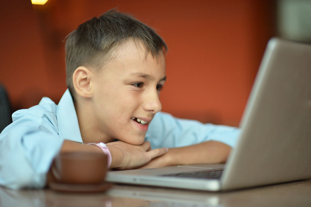 Child Gen Y watching movie or show via Macbook laptop