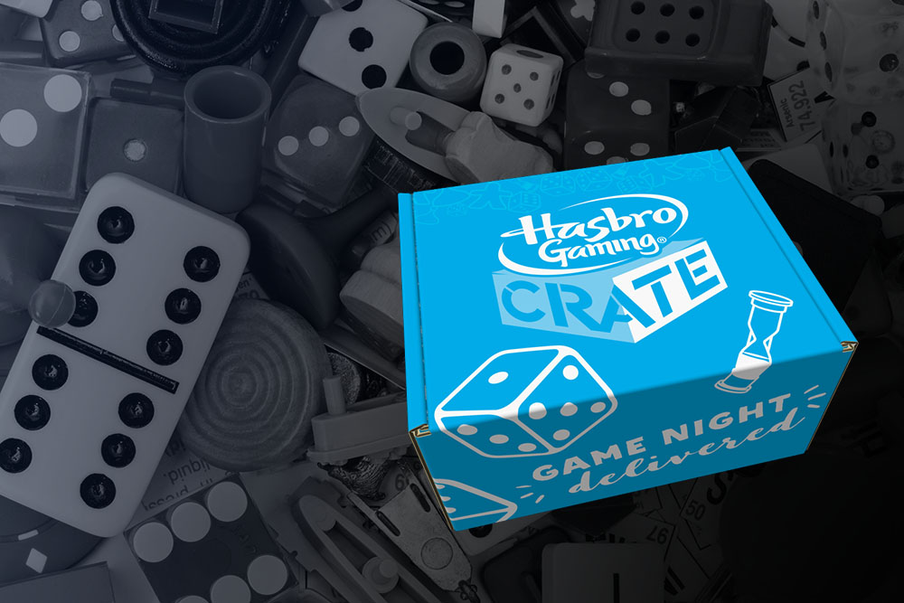 Hasbro game crate shipping box with a background of misc gaming pieces