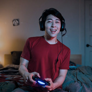 Millenial Male Gamer using Astro A10 headset while gaming