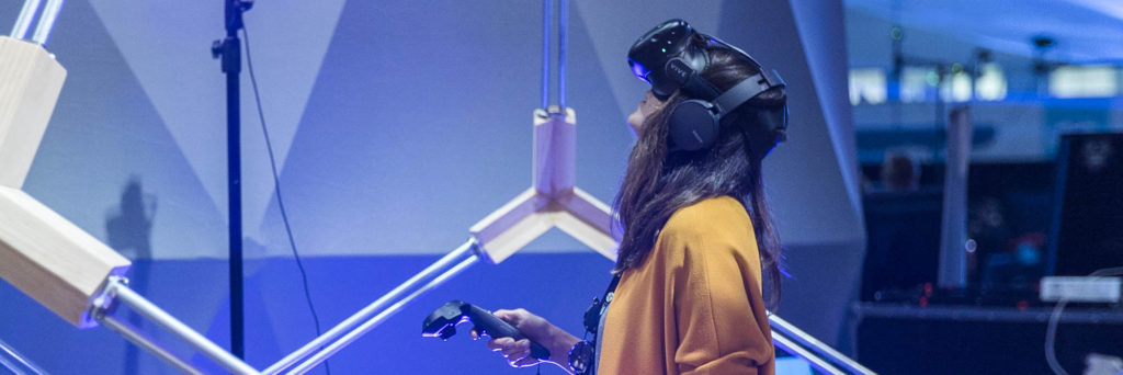 Woman wearing HTC Vive Virtual Reality Headset and playing game
