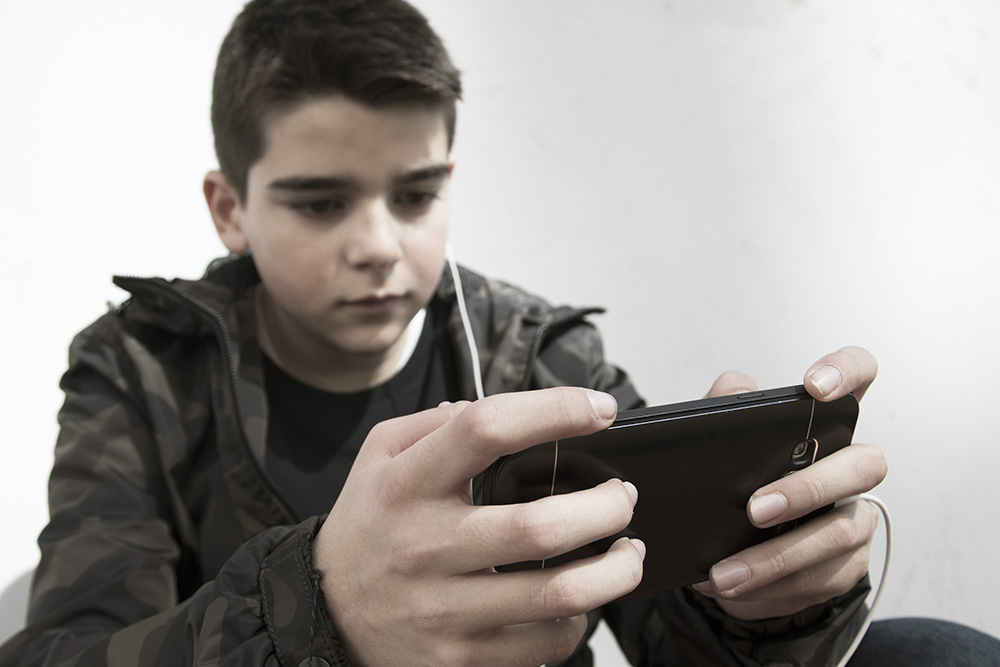 Young boy gaming on mobile phone