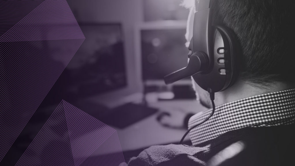 Man wears headset playing desktop video games